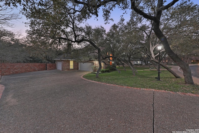 view of front of home featuring a yard, a garage, and driveway