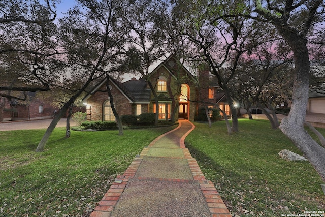 view of front facade featuring stone siding, a front lawn, and a tile roof