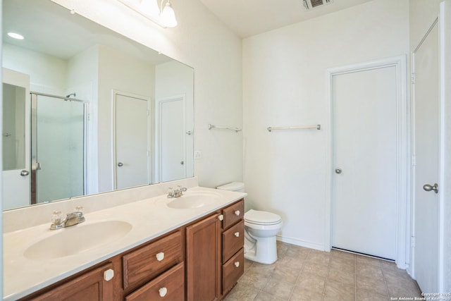 bathroom with a shower stall, double vanity, visible vents, and a sink