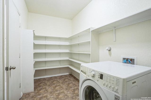 laundry room featuring washer / clothes dryer, laundry area, and stone finish floor