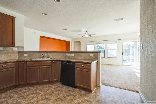 kitchen featuring tasteful backsplash, ceiling fan, black dishwasher, a peninsula, and a sink