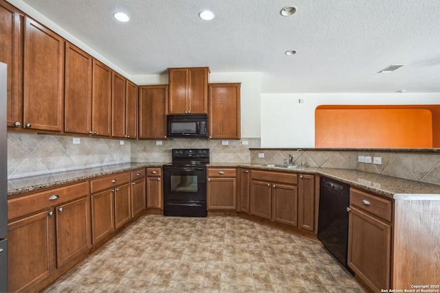 kitchen with a sink, brown cabinets, black appliances, and a peninsula