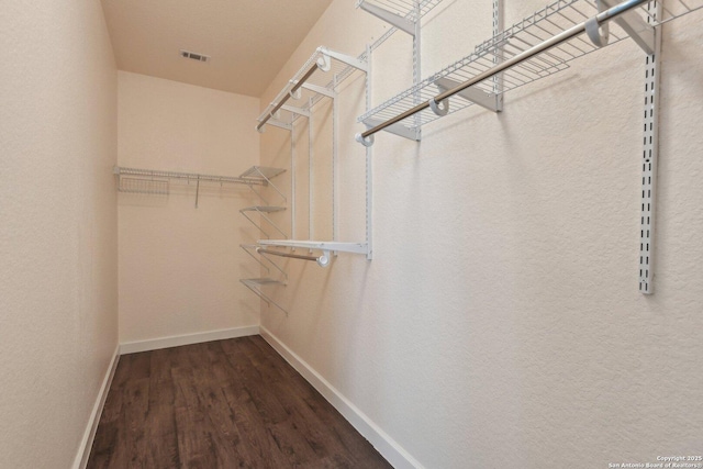 spacious closet with visible vents and dark wood-style floors