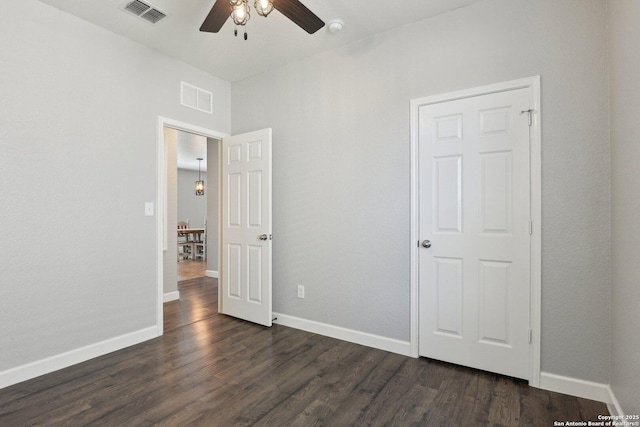 unfurnished bedroom with baseboards, visible vents, and dark wood-style flooring