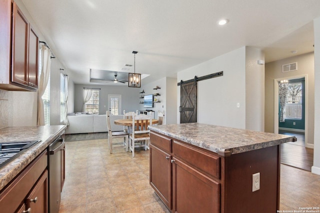 kitchen featuring visible vents, a ceiling fan, open floor plan, a barn door, and dishwasher