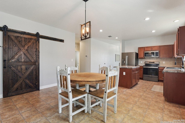 dining area featuring a barn door, a notable chandelier, recessed lighting, and baseboards