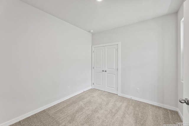 spare room with baseboards and carpet floors