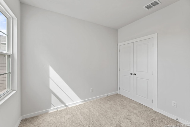 interior space featuring a closet, visible vents, baseboards, and carpet floors