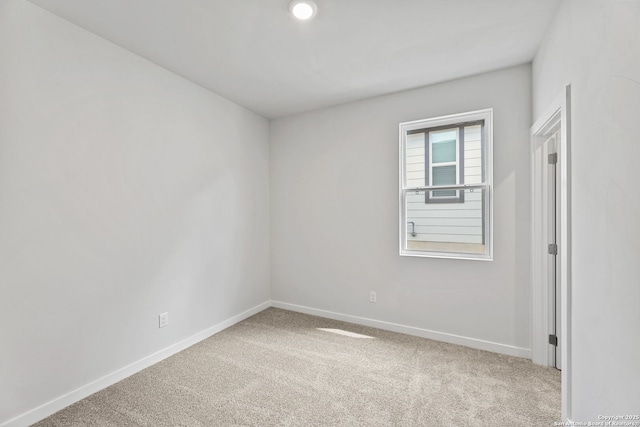 carpeted empty room with baseboards