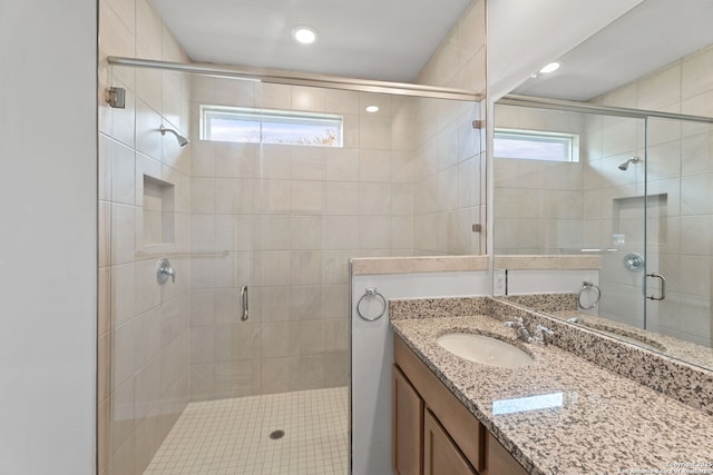 bathroom with recessed lighting, a stall shower, and vanity