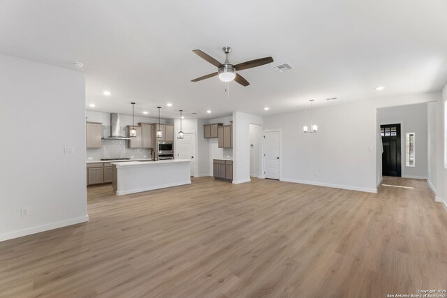 13223 Edith Gdns, San Antonio, TX 78253 - unfurnished living room featuring recessed lighting, visible vents, light wood-style flooring, and ceiling fan with notable chandelier