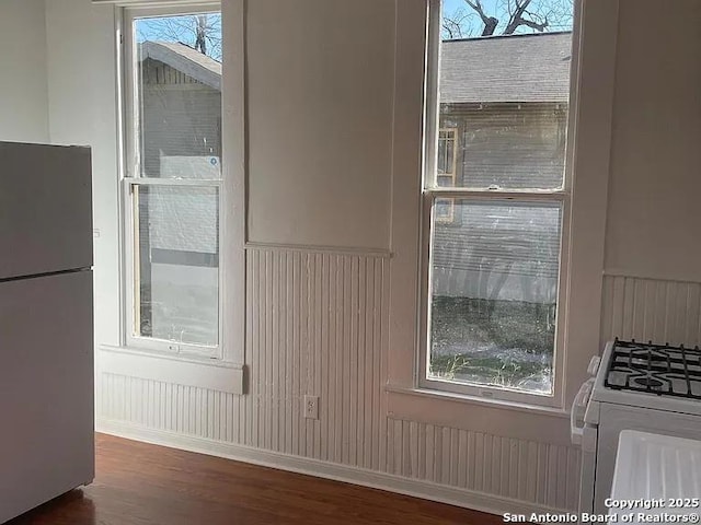 interior space with freestanding refrigerator and wood finished floors