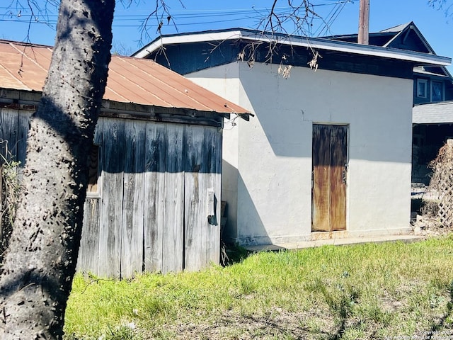 view of property exterior featuring a standing seam roof, stucco siding, and metal roof