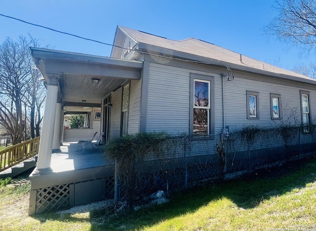 view of side of property featuring covered porch