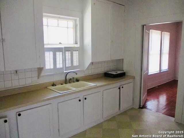 kitchen with a healthy amount of sunlight, white cabinetry, and a sink