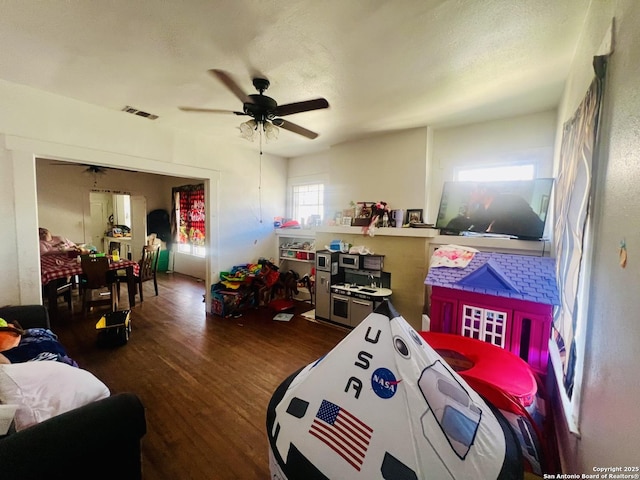 bedroom with ceiling fan, visible vents, a textured ceiling, and wood finished floors