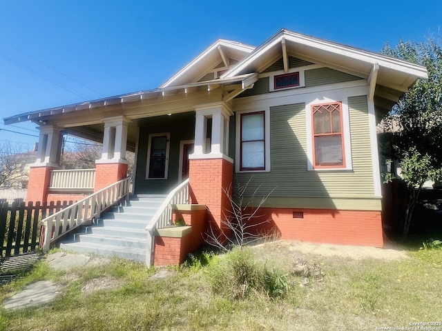 view of front of home featuring a porch, fence, and crawl space