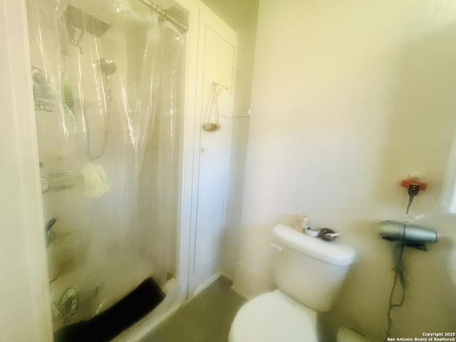 bathroom featuring a shower stall and toilet