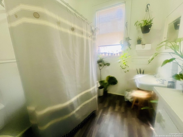 full bath featuring a shower with shower curtain and wood finished floors