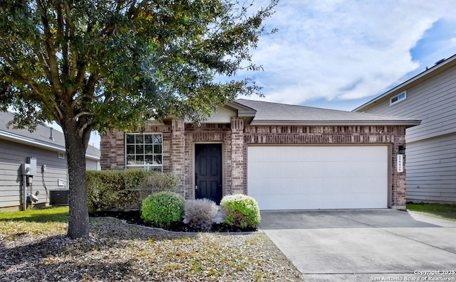 single story home with brick siding, central air condition unit, concrete driveway, and a garage