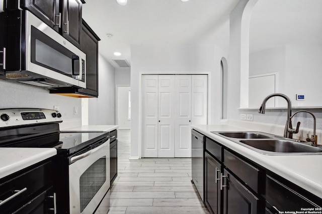 kitchen with visible vents, wood tiled floor, light countertops, stainless steel appliances, and a sink