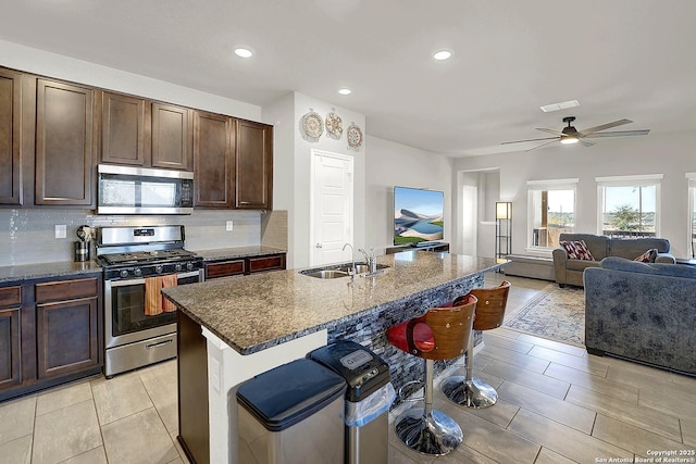 kitchen with tasteful backsplash, visible vents, a breakfast bar area, appliances with stainless steel finishes, and a sink