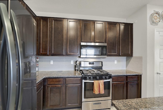 kitchen featuring dark brown cabinets, stone countertops, and stainless steel appliances