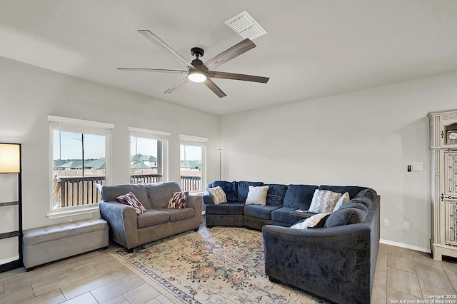 living room featuring visible vents, baseboards, and ceiling fan