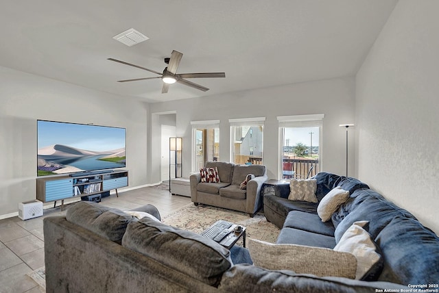 living room with a ceiling fan, visible vents, and baseboards