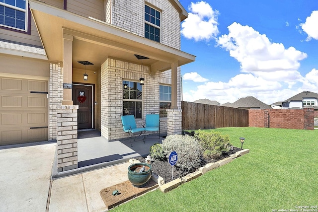 doorway to property with a porch, fence, a yard, a garage, and brick siding