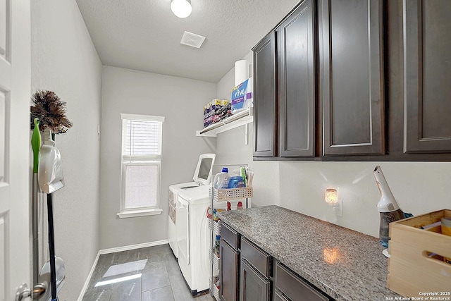 washroom with visible vents, baseboards, cabinet space, a textured ceiling, and washing machine and dryer