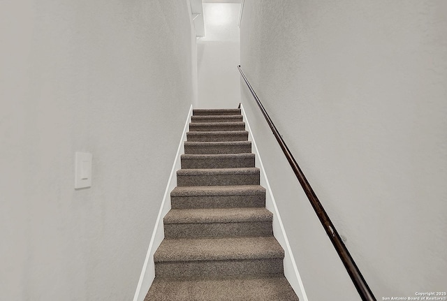 stairs with baseboards and carpet flooring