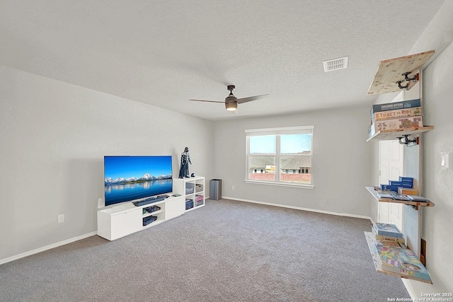 unfurnished living room with visible vents, a textured ceiling, carpet floors, baseboards, and ceiling fan