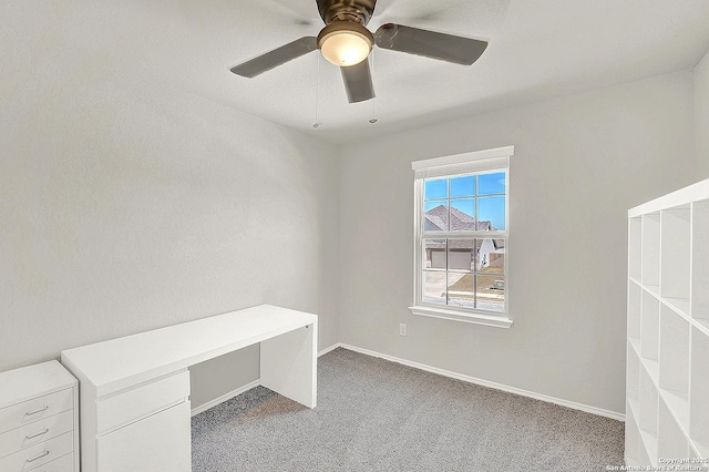 unfurnished office featuring baseboards, carpet floors, and a ceiling fan