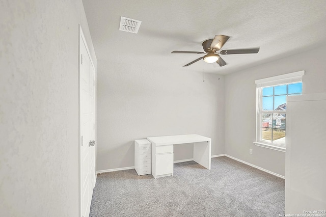 unfurnished bedroom with a ceiling fan, baseboards, visible vents, carpet floors, and a textured ceiling