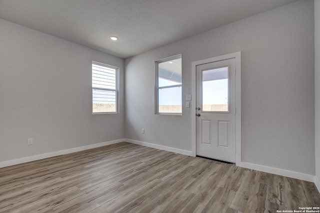 foyer with baseboards and wood finished floors