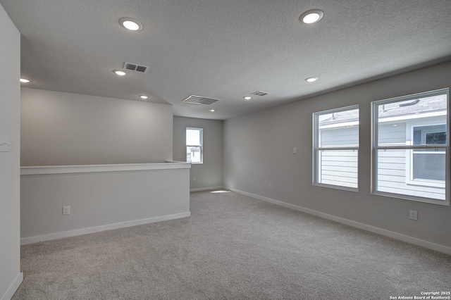 carpeted spare room with visible vents, recessed lighting, and baseboards