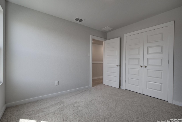 unfurnished bedroom featuring a closet, visible vents, baseboards, and carpet