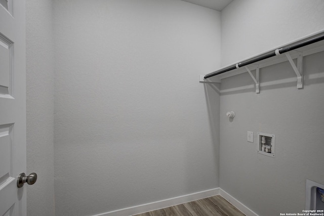 washroom featuring baseboards, gas dryer hookup, washer hookup, laundry area, and wood finished floors