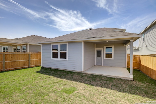 back of property with a fenced backyard, a yard, and a patio