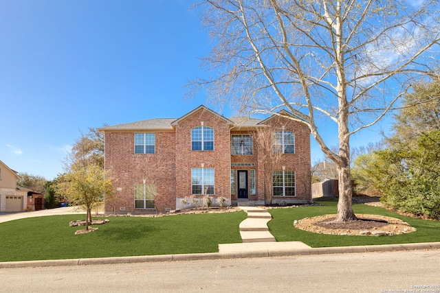 colonial inspired home featuring a front lawn, fence, concrete driveway, a garage, and brick siding