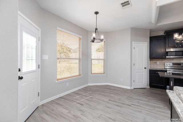 dining space with a wealth of natural light, visible vents, a chandelier, and light wood-style flooring