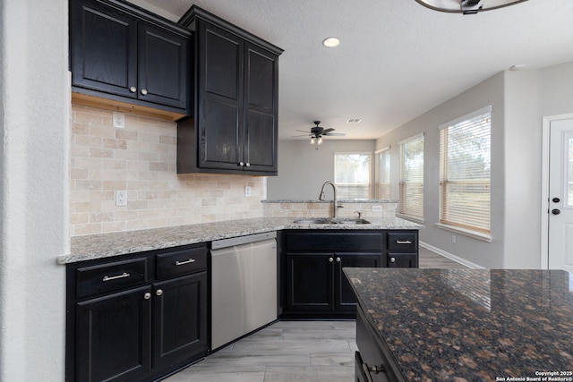 kitchen featuring dishwasher, ceiling fan, dark cabinets, and a sink