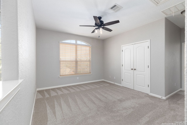 unfurnished bedroom featuring visible vents, baseboards, carpet floors, a closet, and a ceiling fan
