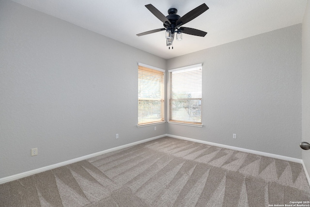 carpeted spare room with baseboards and ceiling fan