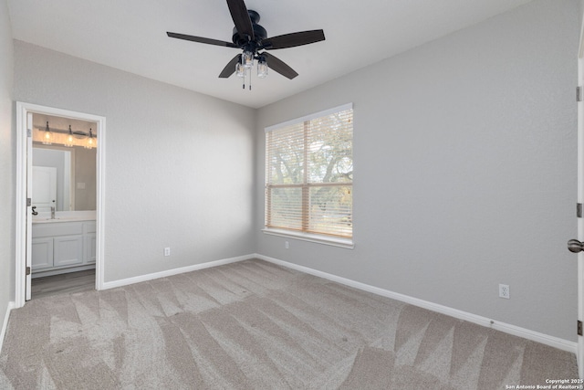 unfurnished bedroom with connected bathroom, baseboards, ceiling fan, and carpet flooring