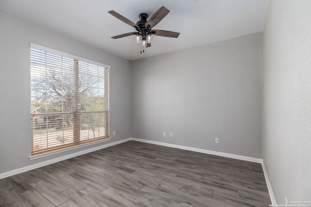 empty room with a ceiling fan, wood finished floors, and baseboards