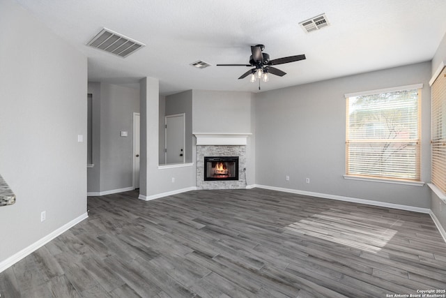 unfurnished living room featuring dark wood finished floors, visible vents, and a ceiling fan