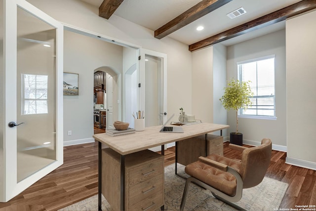 home office with visible vents, arched walkways, baseboards, and dark wood-style floors