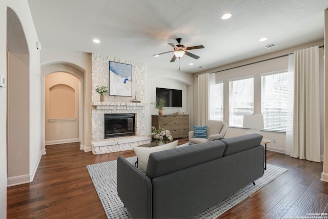 living area featuring dark wood finished floors, baseboards, and ceiling fan